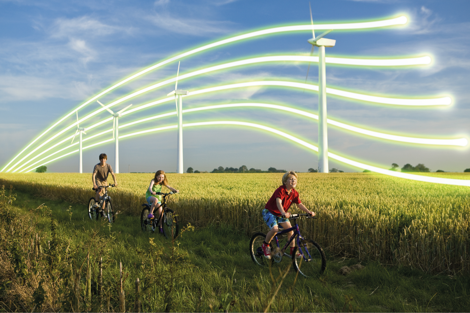 3 children on bicycles in front of wind turbines in a wheat field.